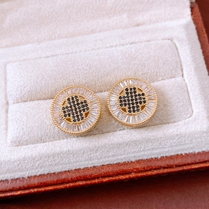 Detailed close-up of 18k gold plated round stud earring with black clover and white zircons