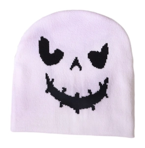 Close-up of pink knitted beanie featuring a black ghost face pattern for Halloween