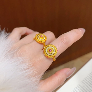 Détail d'une bague vintage plaquée or avec rubis et émail portée au doigt