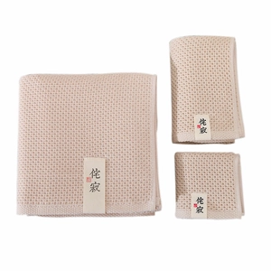 Absorbent waffle weave cotton towels in beige, shown in three different folding styles