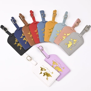 Detailed flat lay of eleven colorful PU leather luggage tags with gold world map embossing