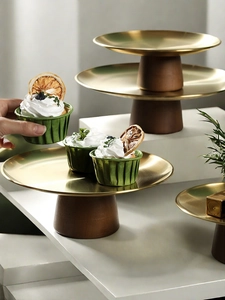 Detailed view of elegant gold metal dessert stands with tiered dark wood pedestal bases