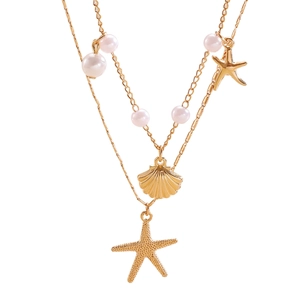 Dettaglio della collana a doppio strato in oro con stella marina, conchiglia e perle