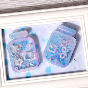 Detail of blue and purple gradient perfume bottle resin charms with glitter and sequins