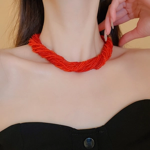 Primo piano della collana bohémien rossa a più fili di perline intrecciate sul collo