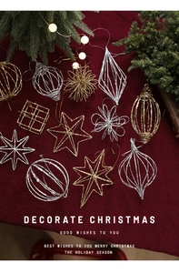 Flat lay of gold and silver glitter Christmas ornaments on burgundy striped fabric