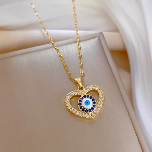 Macro shot of gold heart necklace with evil eye pendant and sparkling zircons