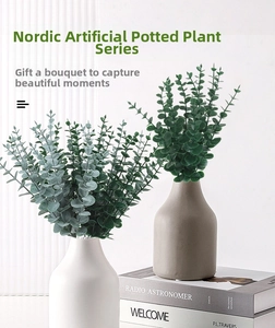 Detail of artificial eucalyptus leaves in minimalist ceramic vases for home decor