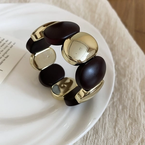 Detail of vintage acrylic elastic bracelet with gold metal and dark brown oval links