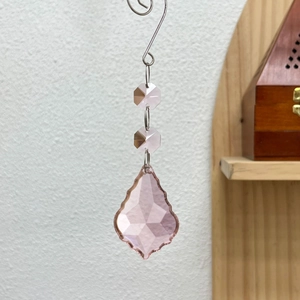 Macro detail of a 50mm pink maple leaf crystal suncatcher with octagonal beads