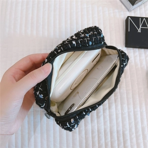 Interior view of tweed cosmetic bag holding a smartphone and power bank inside