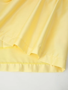 Vue détaillée du tissu en satin jaune lisse avec couture d'ourlet professionnelle