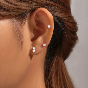 Detailed close-up of 925 sterling silver earrings set with butterfly and pearl on ear