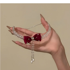 Detail of burgundy silk bow choker with sparkling crystal tassels and white pearls