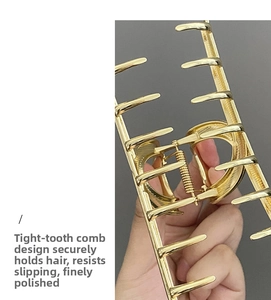 Macro shot of large golden metal hair claw showing strong spring and non-slip teeth detail