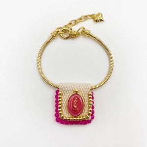 Detail of golden snake chain bracelet with Virgin Mary icon and woven fabric centerpiece