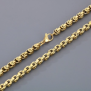 Détails de la maille byzantine dorée et du fermoir mousqueton sur collier en acier inoxydable