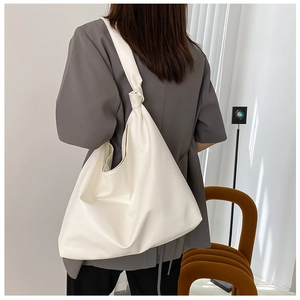 Detail of the white large-capacity hobo bag featuring a stylish wide knotted shoulder strap