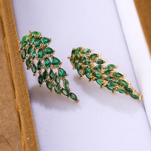 Elegante gouden blad oorbellen met groene druppelstenen in een luxe esthetiek