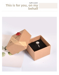 Close-up of vintage brown kraft paper jewelry box with a red rose and a silver flower ring
