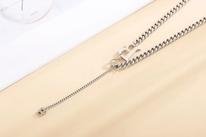 Dettaglio della collana in argento con pendenti lettere R e B in maglia cubana