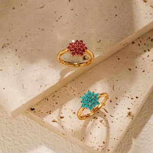 Detail of adjustable flower rings with red gemstone and turquoise in 18K gold plating