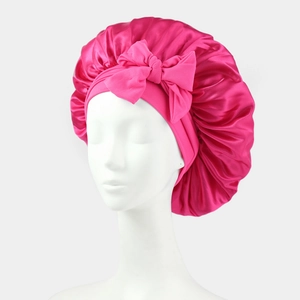 Detailed close-up of a rose red satin sleep cap featuring a large decorative bow