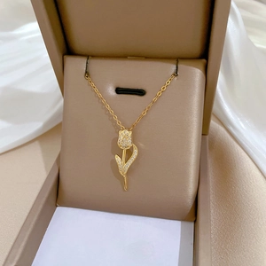 Pendentif tulpe en or élégant avec cristaux brillants dans un écrin à bijoux marron