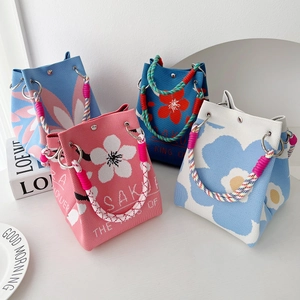 Chic knit bucket bags with floral patterns and colorful woven handles in four vibrant colors