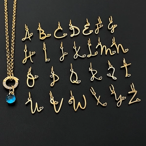 Detailed view of 26 cursive gold alphabet pendants with heart charms for DIY necklace making
