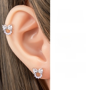 Detail view of bow-shaped stud earrings featuring sparkling white zircon on silver finish