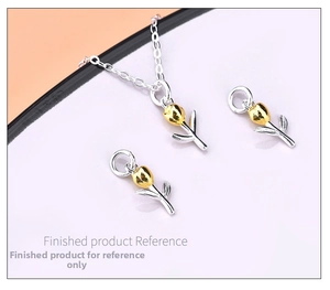 Macro detail of tulip-shaped 925 silver pendant with gold accents and fine link chain