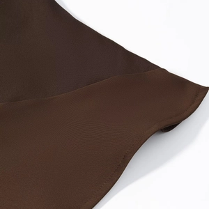 Detailed close-up of dark brown satin fabric texture and neat stitching on casual top