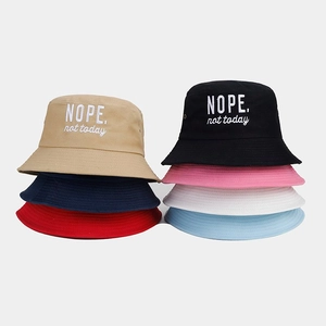 Detailed stack of cotton bucket hats with 'NOPE.' embroidery in seven diverse colors