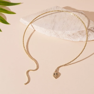 Détail macro du collier serpent doré avec un sertissage de cristaux scintillants