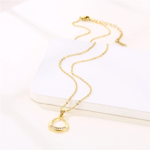 Collana dorata con ciondolo a goccia e zirconi rettangolari su sfondo bianco