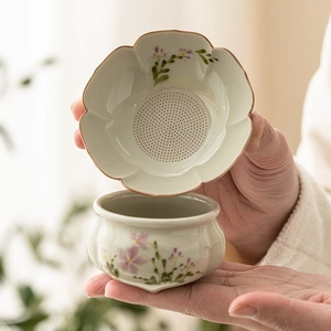Hand-painted daisy ceramic tea strainer set with petal-shaped filter and matching teacup