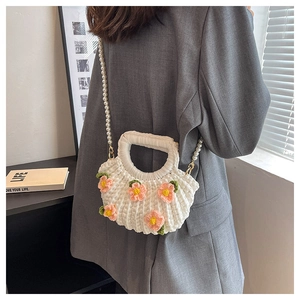 Close-up of handmade crochet shell bag with floral accents and elegant pearl strap