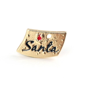 Detail of golden Santa pendant with red heart and hammered metal texture finish