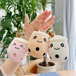 Three cute plush bubble tea keychains in pink, brown and white held by a hand