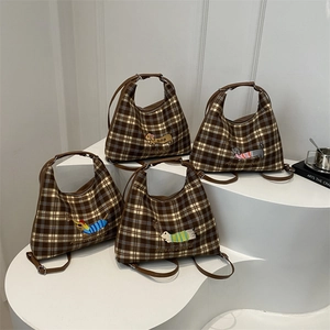 Brown plaid tote bags with cute dachshund embroidery in various colors on white stands