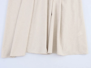 Détail de la texture en lin et du design plissé sur une jupe longue beige