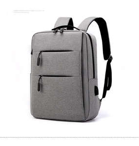 Gray business backpack detail showing USB charging port and tear-resistant fabric texture