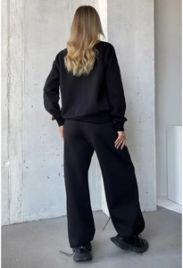 Back view of a black long-sleeve crewneck sweatshirt and loose straight-leg sweatpants set