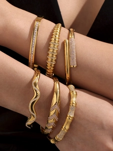 Close-up of gold-plated bamboo and zircon bangles stacked on a female wrist