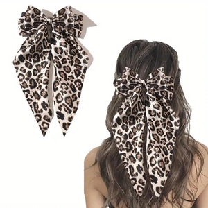Elegant leopard print bow hair clip with satin ribbon streamer shown on model