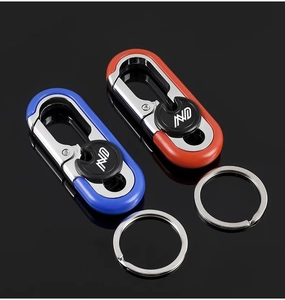 Close-up of premium metal car keychains with blue and orange plastic accents on black background