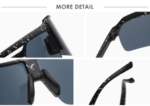 Detail view of black cycling sunglasses with white splattered pattern and reinforced hinges