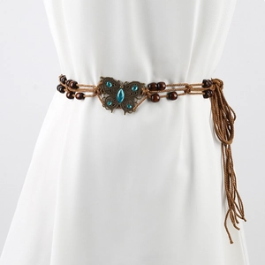 Close-up of bohemian woven rope belt with bronze butterfly buckle and turquoise stone