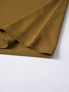 Detailed close-up of premium knit polo shirt hem with reinforced double-needle stitching